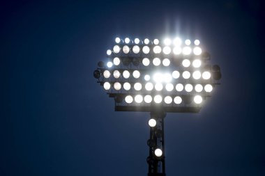 Stadyum ışıkları siyah arkaplanı yansıtıyor