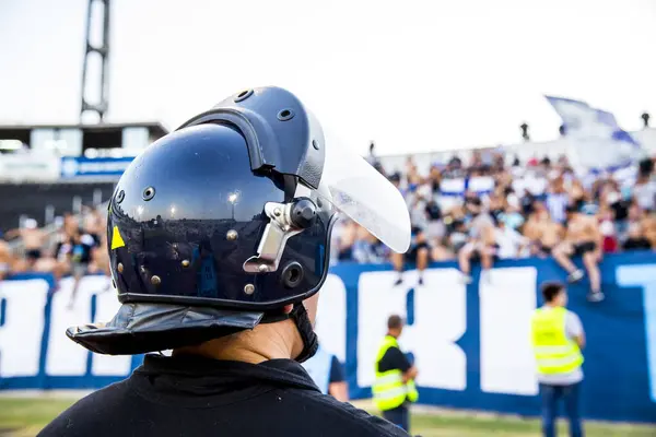 Futbol müsabakası sırasında stadyumda üniformalı itfaiyeciler.