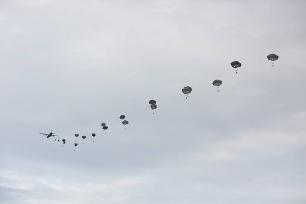 множество парашютистов в облачном небе 