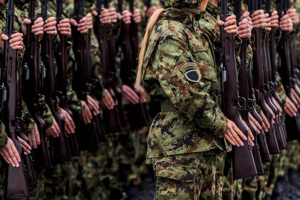 Soldiers stand in row. Gun in hand. Army, Military Boots lines of commando soldiers in camouflage uniforms