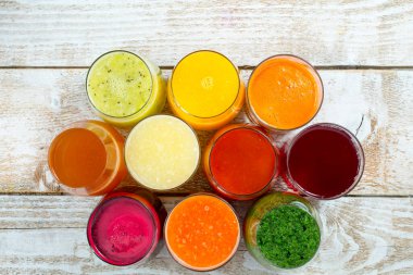 Tahta masada çeşitli meyve ve sebze suları var.