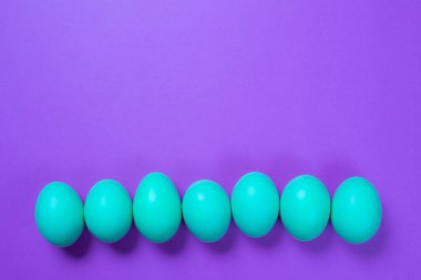 Mor arka planda mavi paskalya yumurtaları
