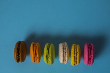 Yukarıdan mavi arkaplanda pasta ya da badem kurabiyeleri, pastel renkler.