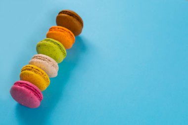 Yukarıdan mavi arkaplanda pasta ya da badem kurabiyeleri, pastel renkler.