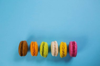 Yukarıdan mavi arkaplanda pasta ya da badem kurabiyeleri, pastel renkler.