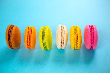 Yukarıdan mavi arkaplanda pasta ya da badem kurabiyeleri, pastel renkler.