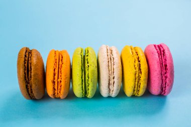 Yukarıdan mavi arkaplanda pasta ya da badem kurabiyeleri, pastel renkler.