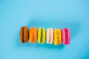 Yukarıdan mavi arkaplanda pasta ya da badem kurabiyeleri, pastel renkler.