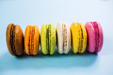 Yukarıdan mavi arkaplanda pasta ya da badem kurabiyeleri, pastel renkler.