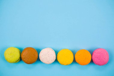 Yukarıdan mavi arkaplanda pasta ya da badem kurabiyeleri, pastel renkler.