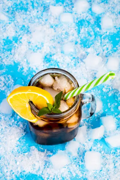 summer drink with ice and lemon on blue background
