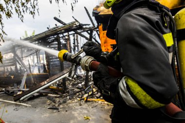 İtfaiyeci yangını suyla söndürüyor.