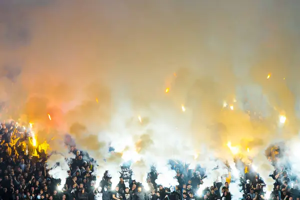 Fans with burning fires during football match on stadium