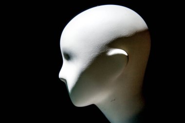 Karanlık arka planda karamsar ışıklandırması olan manken yüzü.