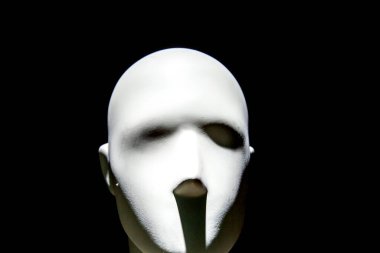 Karanlık arka planda karamsar ışıklandırması olan manken yüzü.