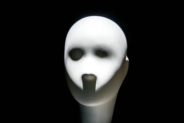 Mannequin face with moody lighting on dark background