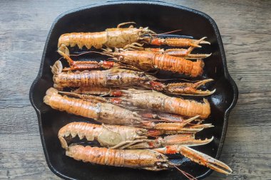 Siyah tavada pişmiş karides.