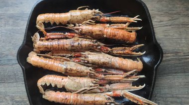 Siyah tavada pişmiş karides.