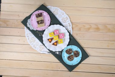 Bir sürü farklı aromalı mini renkli minik kekler.