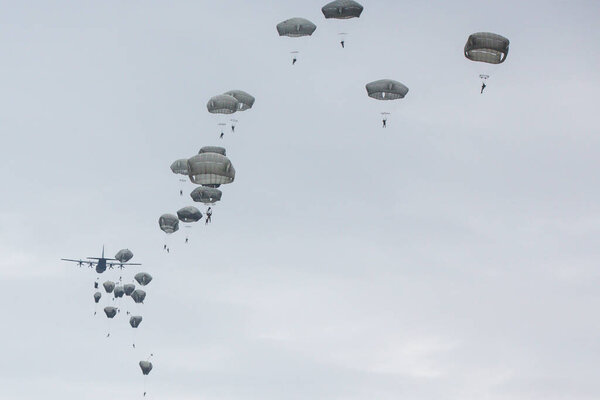 множество парашютистов в облачном небе