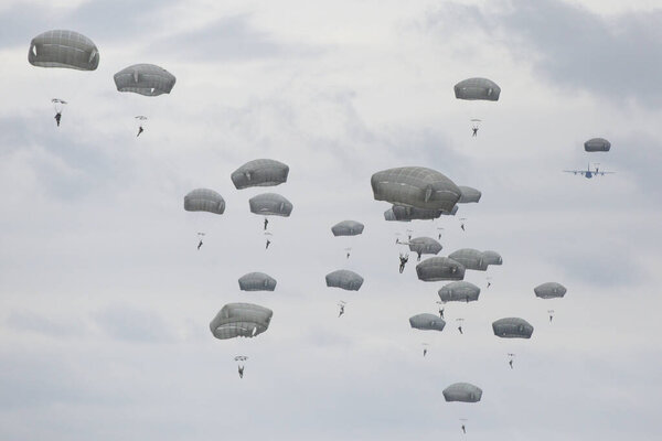 множество парашютистов в облачном небе