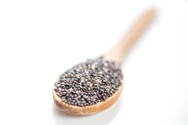 Beyaz arka planda tahta kaşıkta Chia tohumları