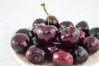 Olgun kırmızı kirazlar beyaz arkaplanda izole edilmiş