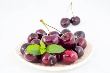 Olgun kırmızı kirazlar beyaz arkaplanda izole edilmiş