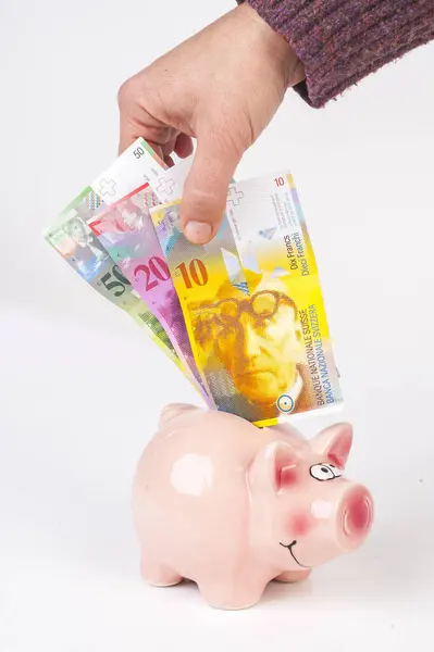 Swiss franc put in a piggy bank