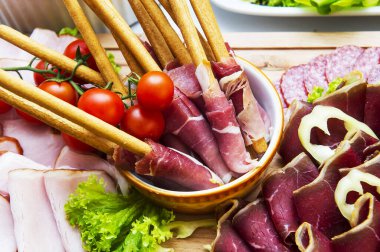 İtalyan jambonu jambon ve arka planda vişneli domates salamı.