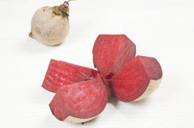 Beyaz ahşap arka planda yaprakları olan taze pancar kökü