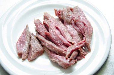 Biftek beyaz tabakta dilimlenmiş.