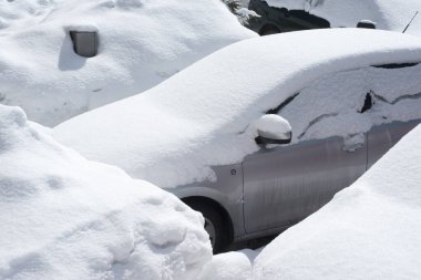 Otoparktaki kar fırtınasında araçlar karla kaplı.