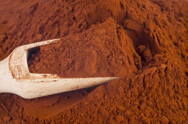 Beyaz arka plan üzerinde izole ahşap kepçe ile kakao tozu yığını