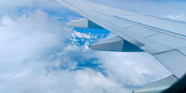Bir uçak penceresinden sakin gökyüzünün tadını çıkarmak, bulutların üzerinde huzurlu bir yolculuk. Manzaralı hava manzarası. Seyahat konsepti, gezgin, gezi, tatil, turizm
