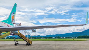Değişim Mai - Tayland. 7 Ekim 2023: Chiang Mai Uluslararası Havalimanı 'ndaki bulutlu güzel mavi gökyüzü ve bir Nok Air uçağının manzarası. Seyahat kavramı