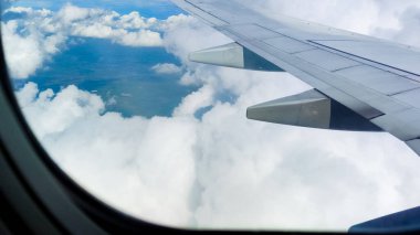 Bir uçak penceresinden gökyüzü ve bulutların havadan görünüşü. Seyahat konsepti. Gezgin, gezi, tatil, turizm, manzara, canlı, doğa, manzara, arka plan