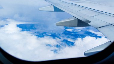 Bir uçak penceresinden bulutlar ve gökyüzü. Hava manzaralı arka plan. Seyahat konsepti. Gezgin, gezi, tatil, turizm, manzara, canlı, doğa, manzara