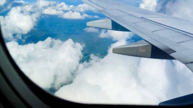 Gökyüzünün havadan görünüşü ve bir uçak penceresinden bulutlar. Seyahat konsepti. Gezgin, gezi, tatil, turizm, manzara, canlı, doğa, manzara. Arkaplan