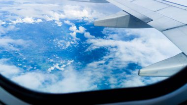 Gökyüzünün güzelliğinin göz kamaştırıcı manzarası ve bir uçak penceresinden bulutlar. Gezgin perspektifi. Seyahat konsepti, gezgin, gezi, tatil, turizm