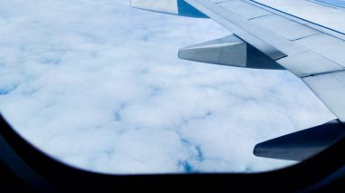 Güzelliğin güzel doğası gökyüzü ve bulutlar bir uçak penceresinden. Seyahat konsepti, gezgin, gezi, tatil, turizm, geçmiş