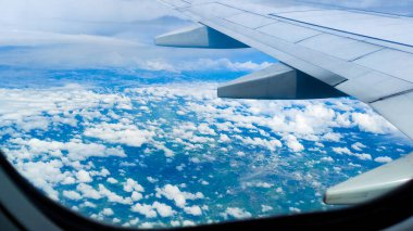 Güzelliğin güzel doğası gökyüzü ve bulutlar bir uçak penceresinden. Seyahat konsepti, gezgin, gezi, tatil, turizm, geçmiş