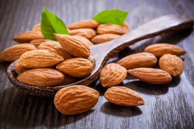 Tahta zemin üzerinde yaprakları olan bademler