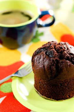 Fresh baked delicious muffins and cup of coffee on table.