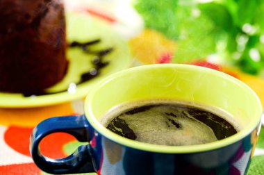 Cup of black coffee with fresh baked delicious muffins.