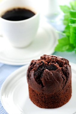 Fresh baked delicious muffins and cup of coffee on table.