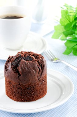 Fresh baked delicious muffins and cup of coffee on table.