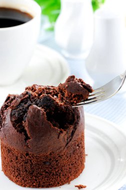 Fresh baked delicious muffins and cup of coffee on table.