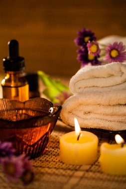Spa aromatherapy with candle and spa set to relax on wooden background.