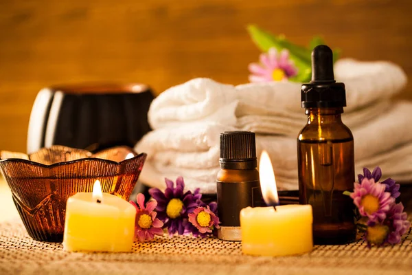Spa aromatherapy with candle and spa set to relax on wooden background.